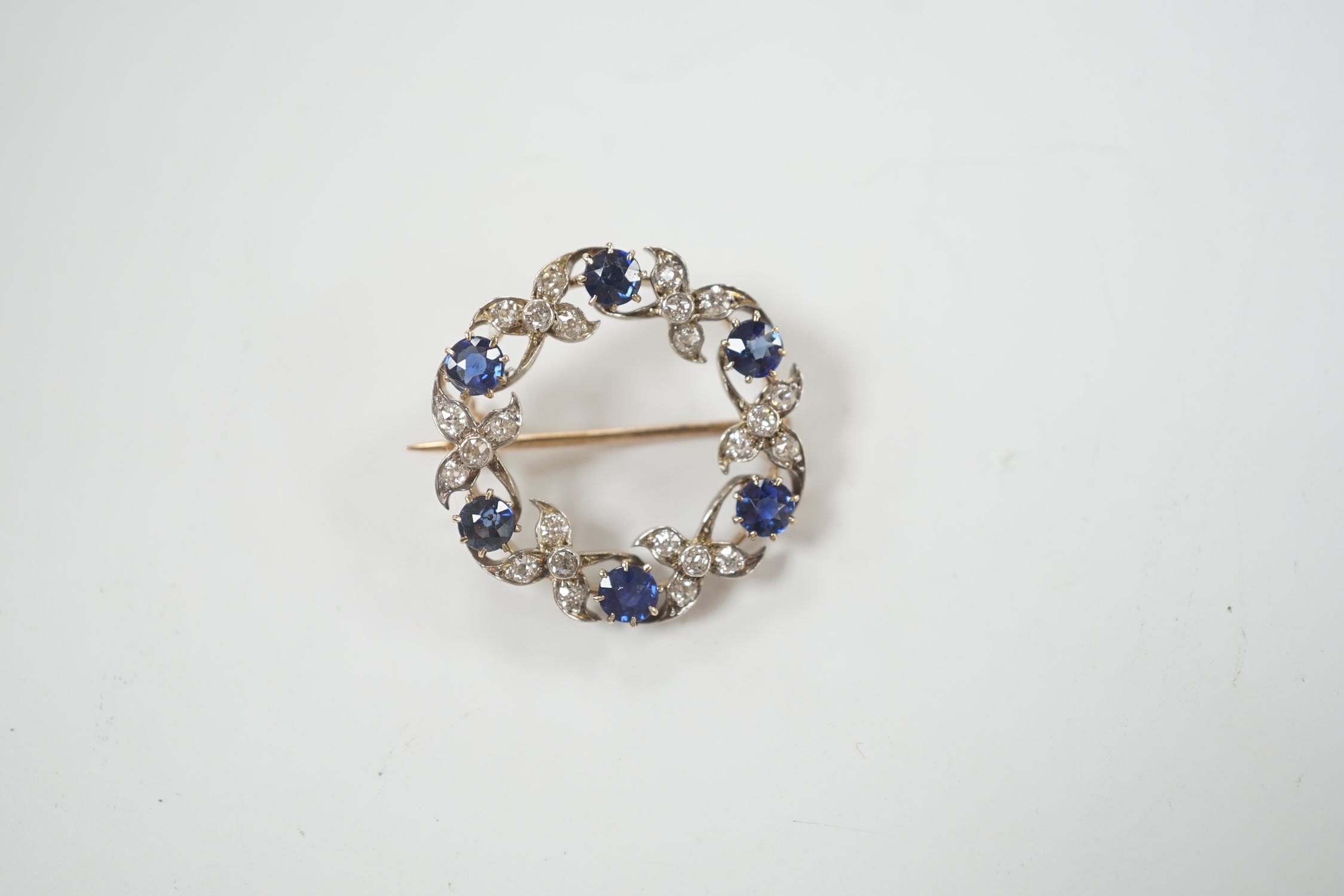 A yellow and white metal, sapphire and diamond cluster set openwork brooch, 24mm, gross weight 4.6 grams.